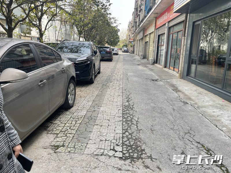 小区道路停满车辆，仅容一车通过。