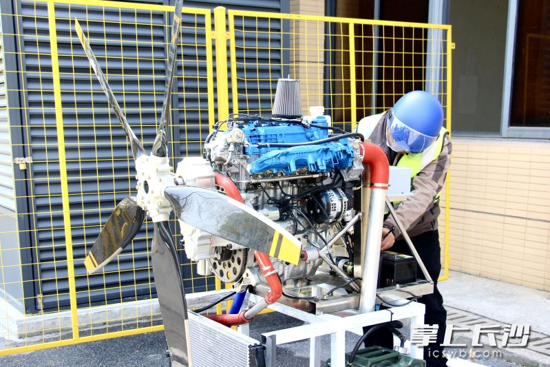 工厂外,工作人员正在操纵实运行航空发动机。 工厂外,工作人员正在操纵实运行航空发动机。