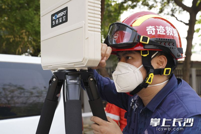 华诺星空工程设计师严冰在救援现场调试水平仪，以便更好地架设救援设备。