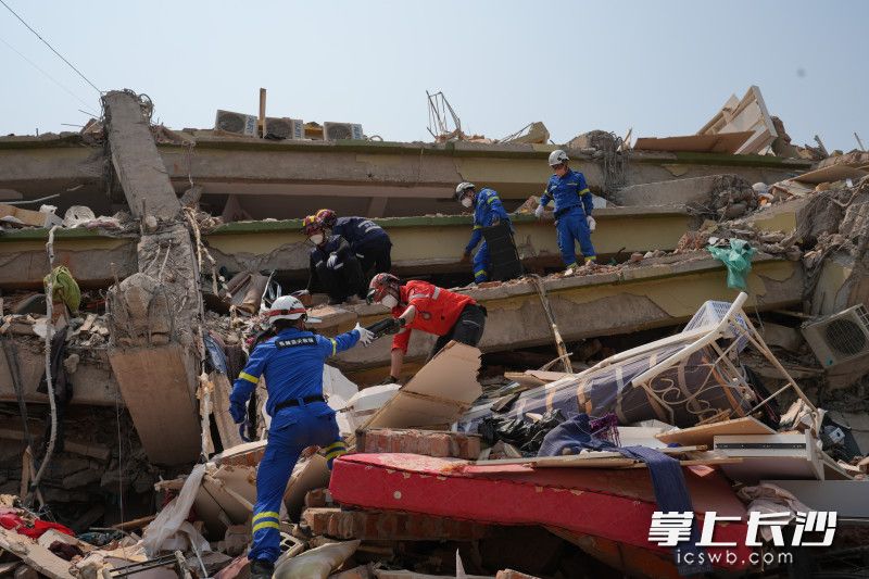 4月2日，在曼德勒受灾最严重的天空公寓酒店，岳麓蓝天救援队队员带着生命探测仪爬到坍塌楼层进行近距离探测，不放弃任何一丝机会。 均为长沙晚报全媒体记者邹麟、周数邑摄