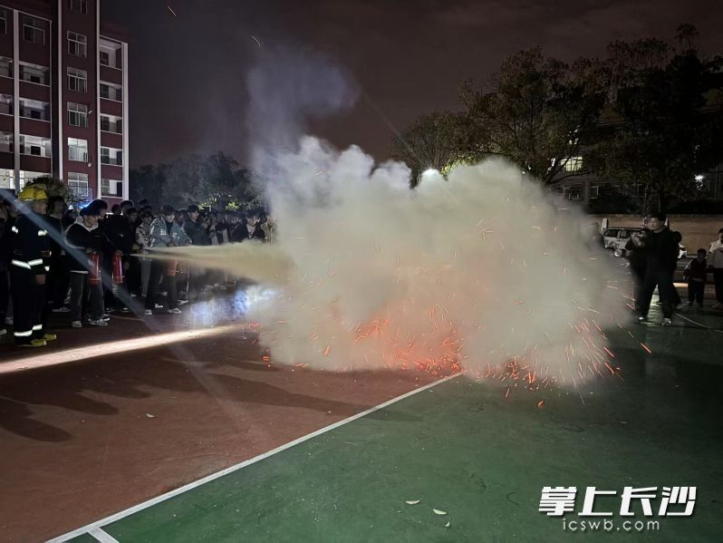 学生们在指导下开展灭火。 学生们在指导下开展灭火。