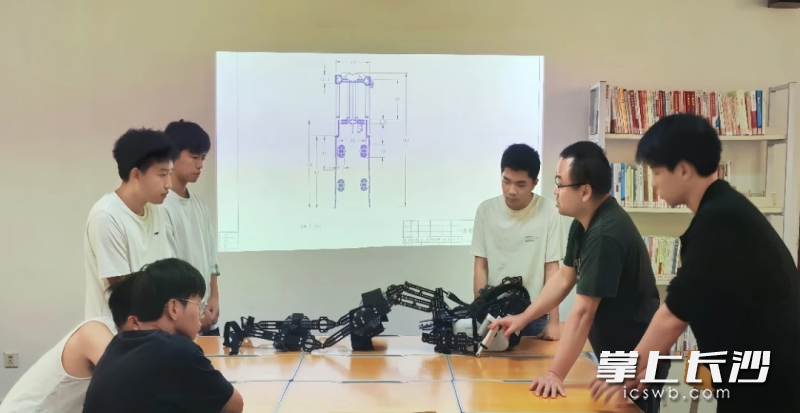 指导老师刘湘冬（右二）与包罗万束工作室成员探讨产品方案。