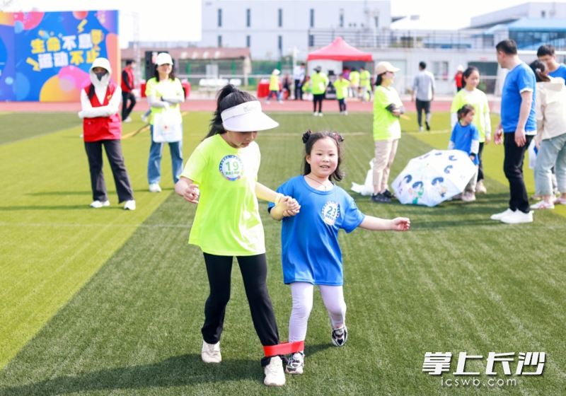 普通儿童与孤独症儿童携手并进，在家长和志愿者的陪伴下，共同完成运动项目。