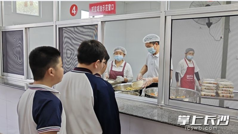 中餐时，学生排队打餐。 长沙晚报全媒体记者 徐媛 摄
