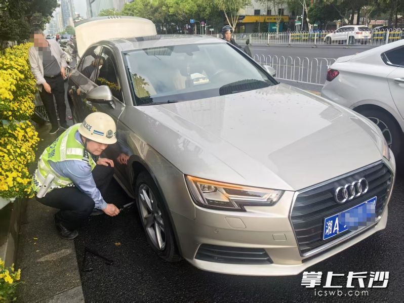 谌光曙见状，脚麻利地为老人更换好了备胎。长沙晚报通讯员 屈省 供图