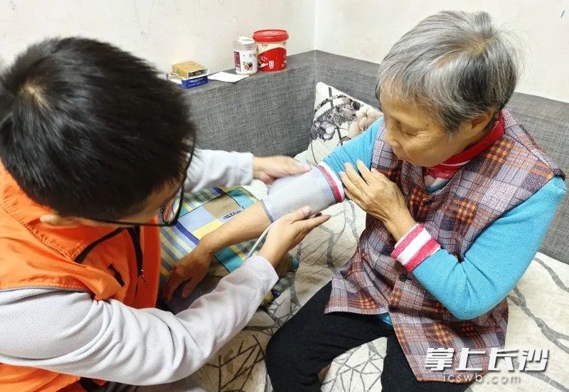 助老员为老人量血压。市民政局供图