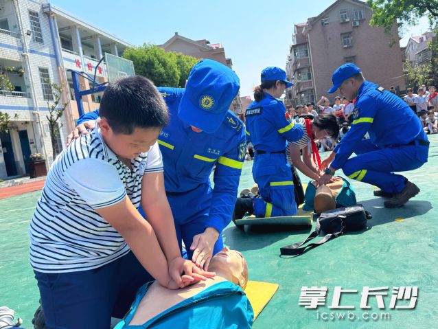 现场学生们在队员指导下体验急救过程。