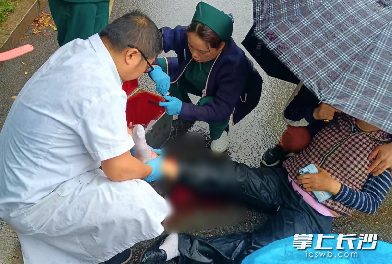 4月19日，湖南航天医院急危重症医学科副主任黄扩军带领护士李卫、刘婷静，暴雨中为伤着进行紧急救治处置。通讯员供图