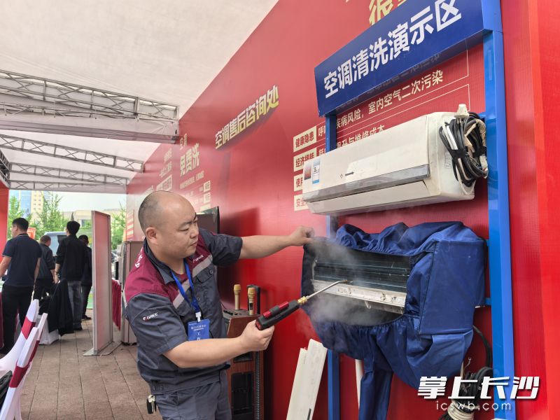 富有经验的师傅为市民消费者演示空调清洗全过程。