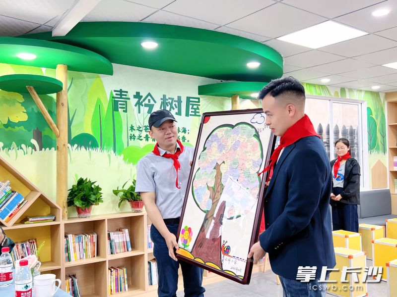 钟宇（左）向爱心人士赠送“爱心树”。