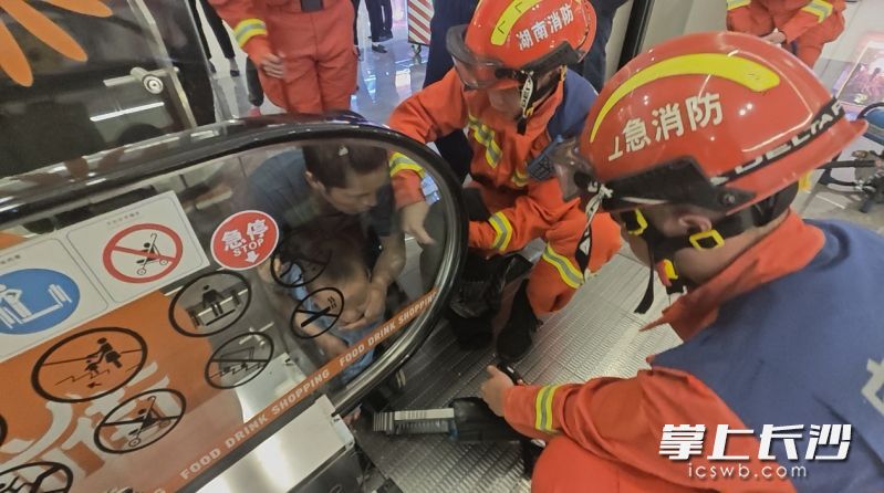 消防员正在救援被扶梯卡手的儿童。 长沙晚报通讯员 杨慧 供图
