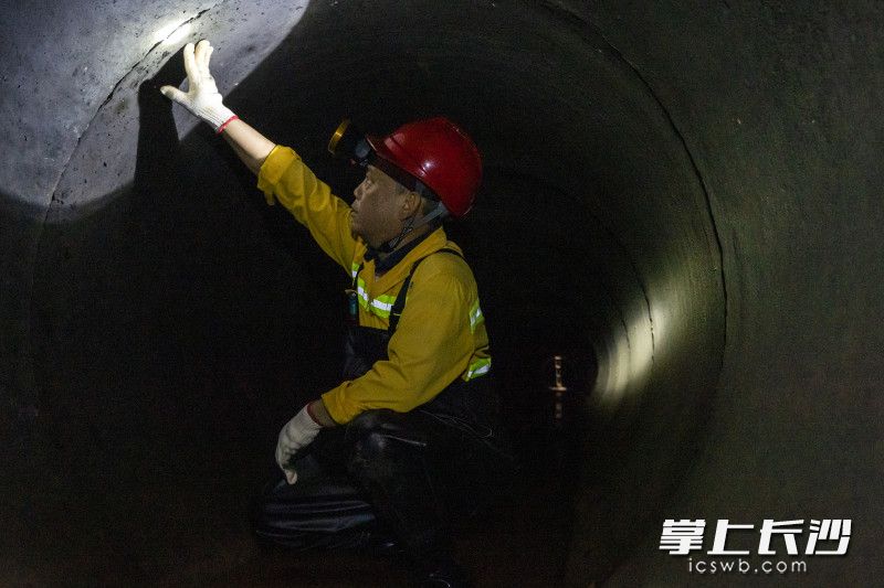 袁勤佝偻着腰边检查管道内情况边告诉记者，平时检查时还要边注意清淤，有很多东西会导致管道堵塞。