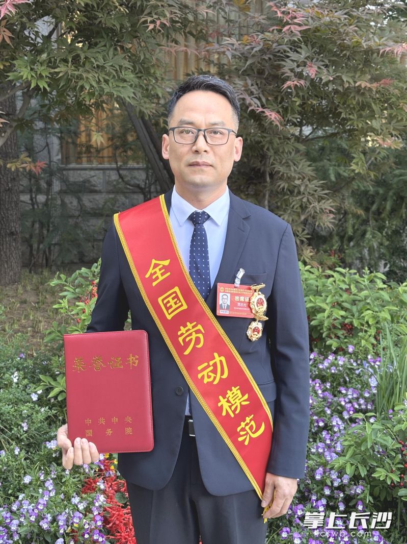 贾志光展示获奖证书和奖章。