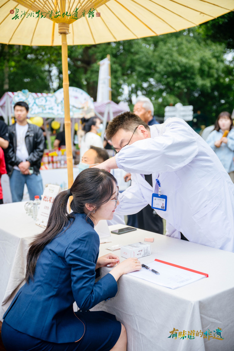 集市一角的义诊区，来自长沙市第三医院的医护人员热情地接待着每一位前来咨询的游客。