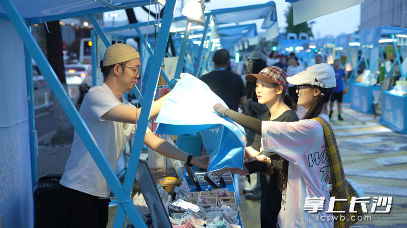 游客们在市集上把青春范、湖湘味的好礼收进行囊打包回家。均为长沙晚报全媒体记者 李卓 摄