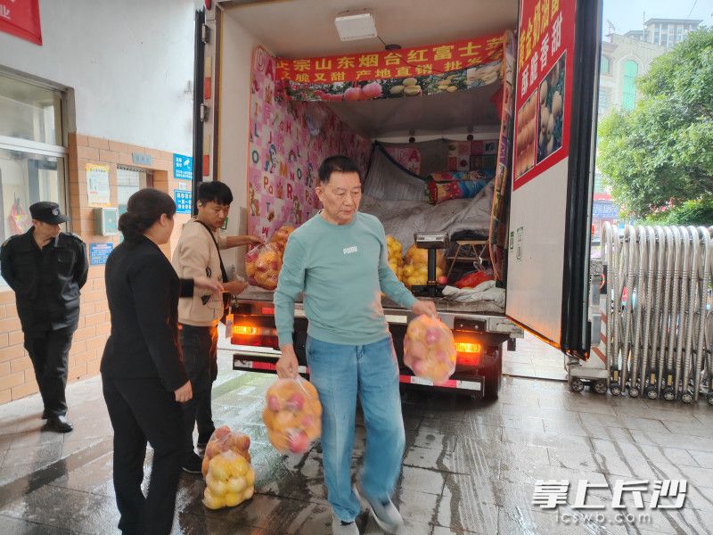 经过精心挑选，周松林（右）购买了280斤烟台红富士苹果，以感谢物业工作人员的辛勤付出。