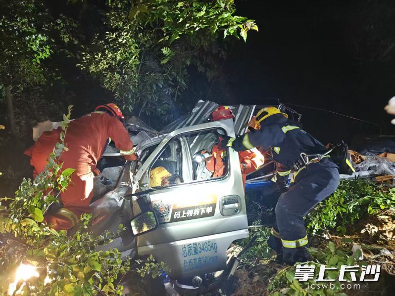 消防员在救助侧翻后被困的货车司机。 长沙晚报通讯员 吴坤 供图