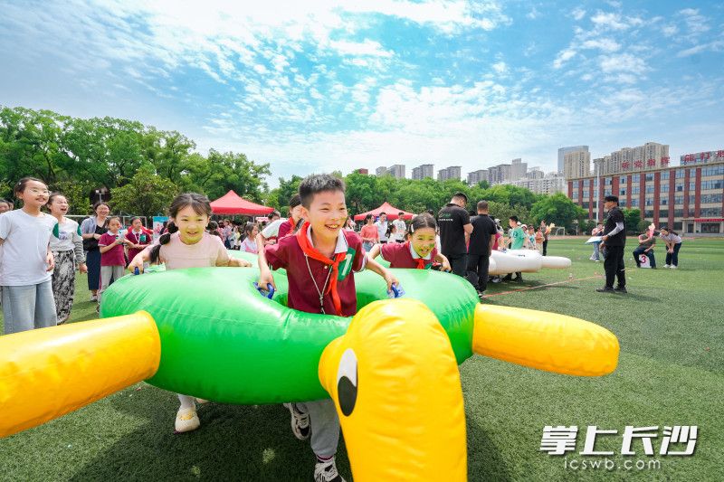 “龟兔赛跑”充气赛道上，孩子们钻进憨态可掬的充气道具，化身“兔子”或“乌龟”携手慢行。