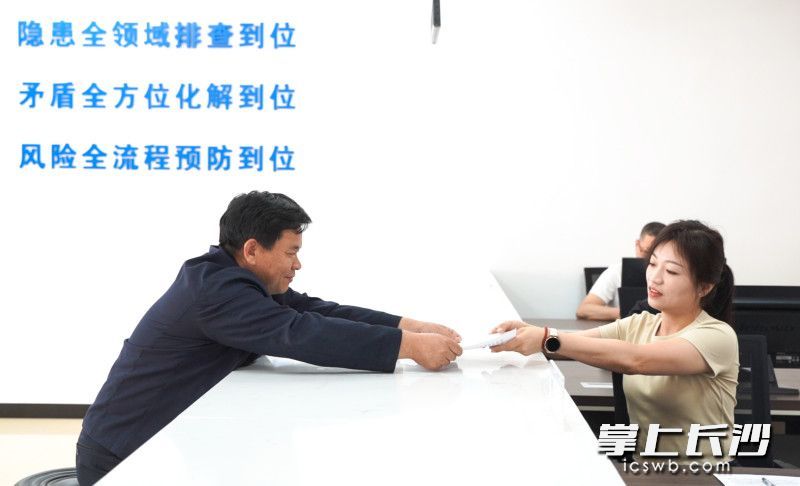 宁乡市夏铎铺镇综治中心里,村民向工作人员递交申请材料。 宁乡市夏铎铺镇综治中心里,村民向工作人员递交申请材料。