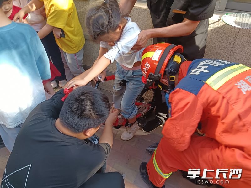 消防员在帮助被困儿童。长沙晚报通讯员 杨慧 摄