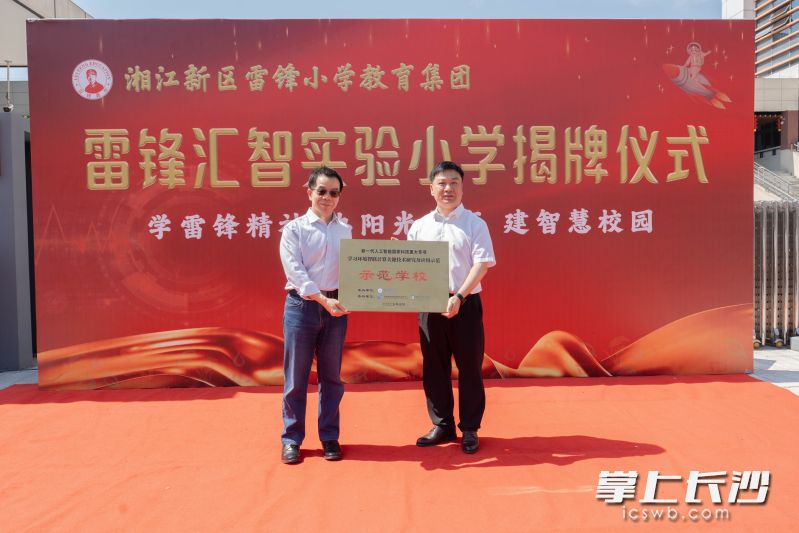 黄荣怀（左）向刘丰华颁发“新一代人工智能国家科技重大专项——学习环境智联计算关键技术研究及应用示范学校”牌匾。