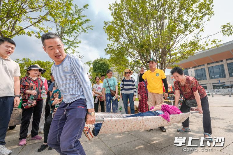 居民在教官指导下，学会用窗帘自制救命担架。 均为长沙晚报全媒体记者陈飞摄