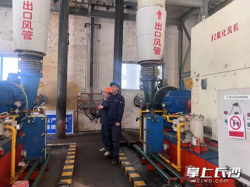 杨飞(右)正在和同事查看设备。 杨飞(右)正在和同事查看设备。