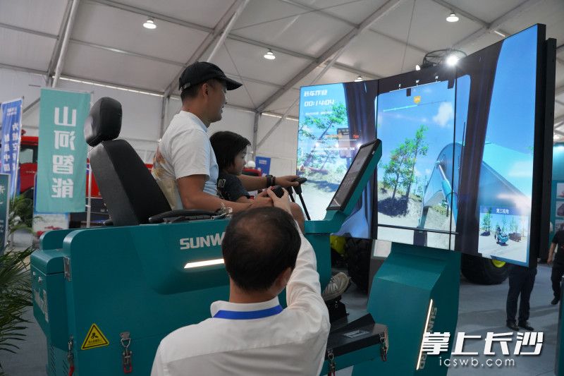 观众通过模拟机器体验开挖掘机。