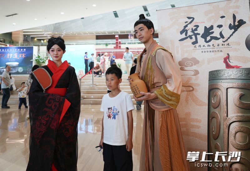 一位小朋友与身穿古装的表演者合影。