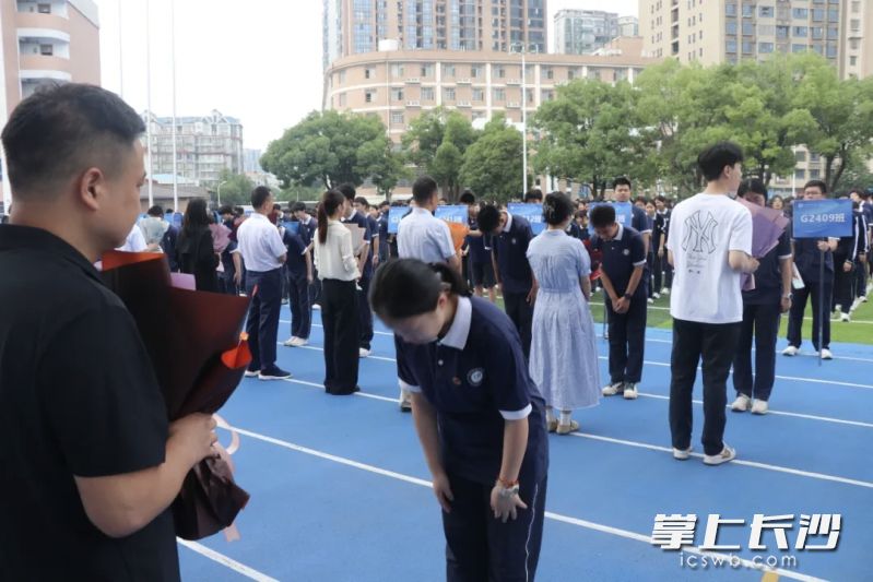 学生代表手捧鲜花走向班主任，以庄重的三鞠躬表达敬意。