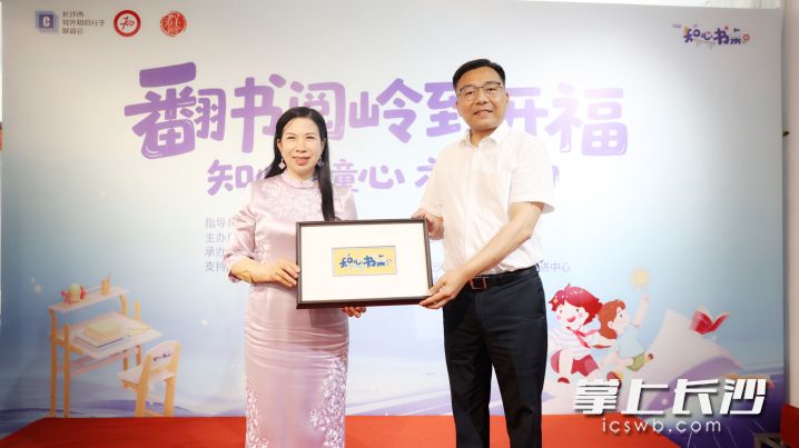 江再红向长沙市知联会赠送“知心书桌”定制湘绣作品。