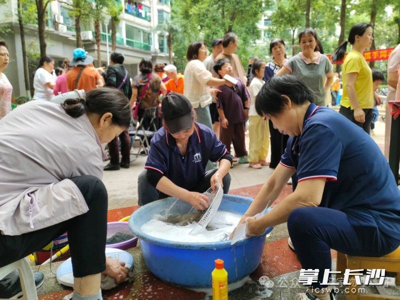 物业工作人员为业主清洗风扇。