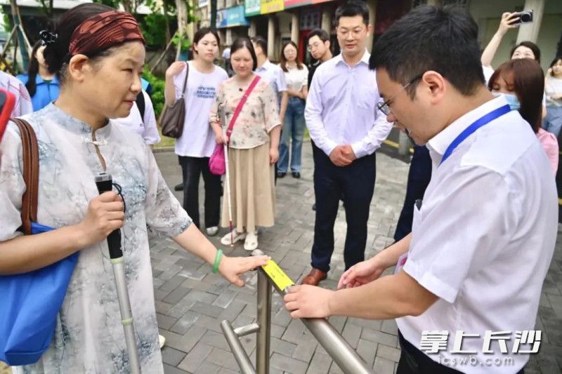 长沙市盲协副主席吴声湄（左一）体验人民东路站6号口盲文铭牌。均为长沙市残联供图