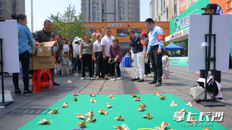 社区居民参加套圈圈游戏。
