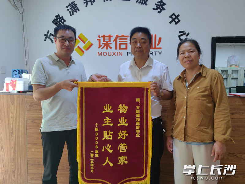 奉先生委托同事（左一）将锦旗送至高云炳（中）、梁银香（右一）手中。受访者供图