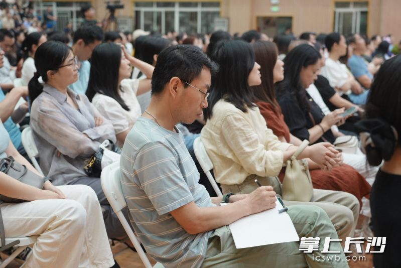 听课家长认真地做笔记。