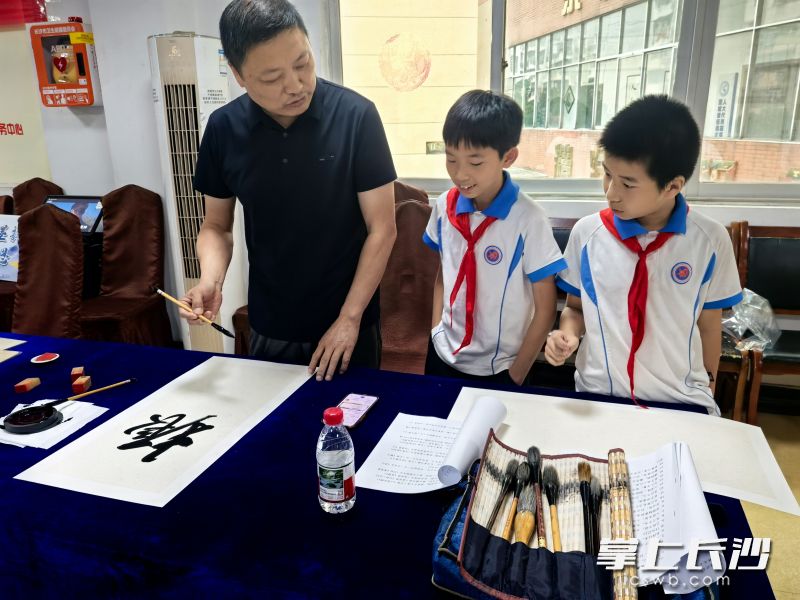 小朋友向书法老师请教。