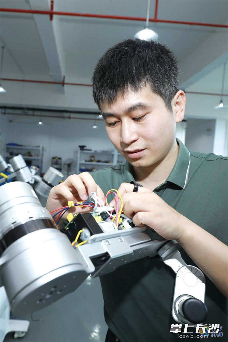 陈彦给机器人控制系统接线。刘珂摄