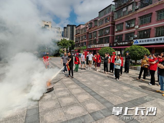 消防教官邀请商户及业主正确使用并操作消防设施。