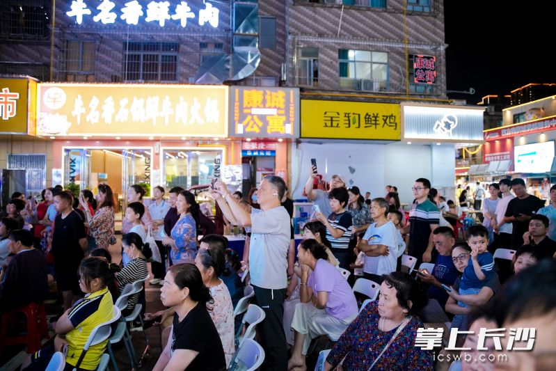 吃着夜宵看文艺演出，游客市民都很过瘾。
