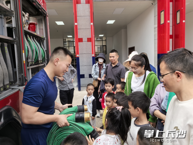 消防员向孩子们展示消防器材。
