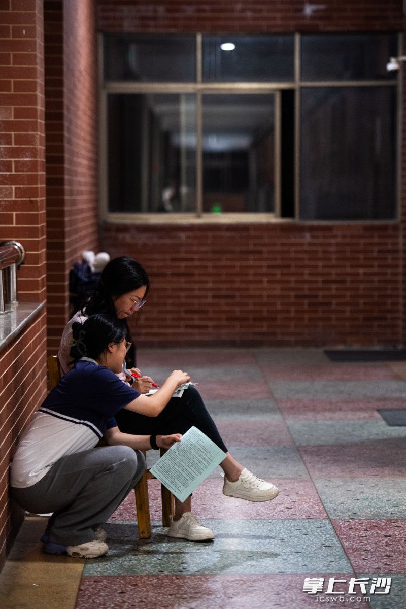 5月29日晚，长沙明德中学，任课老师黄海龙在走廊上为学生解答问题。