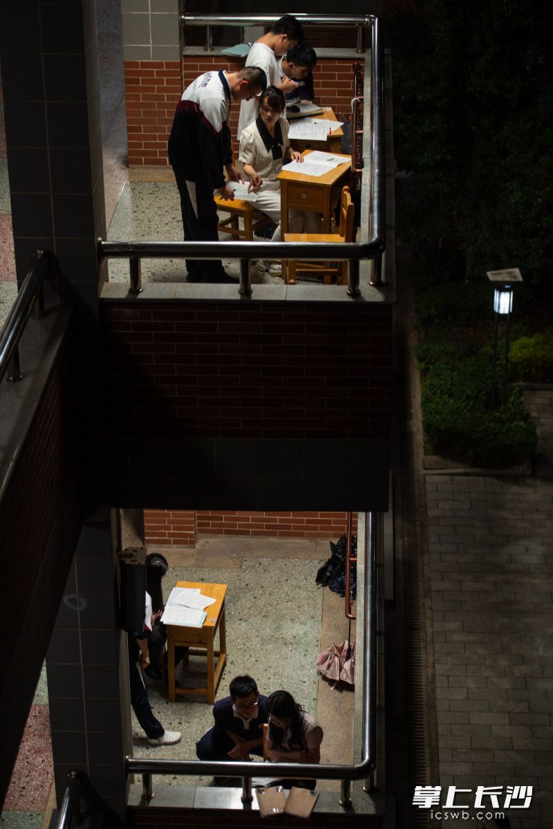 当晚，长沙市明德中学，夜晚的高三教室里灯火通明，同学们在紧张进行冲刺复习。