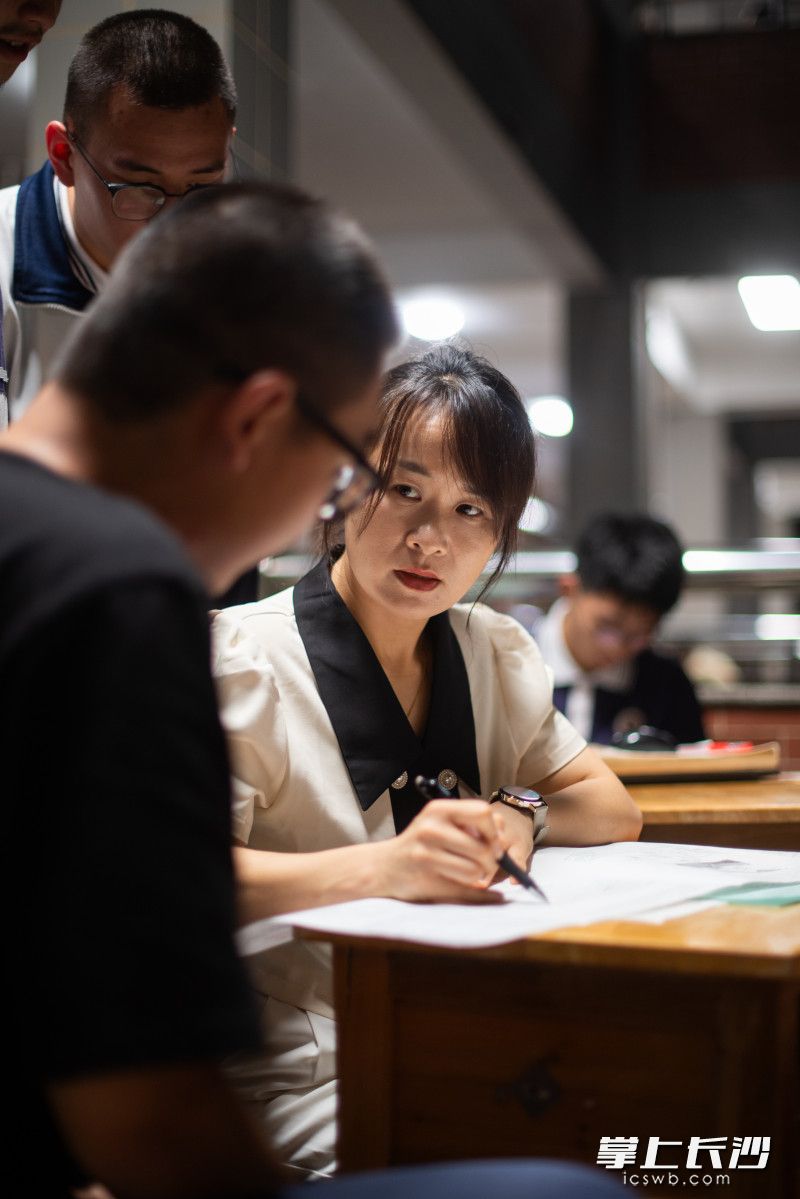 5月29日晚，长沙明德中学，任课老师张江在走廊阳台上为学生解答问题。