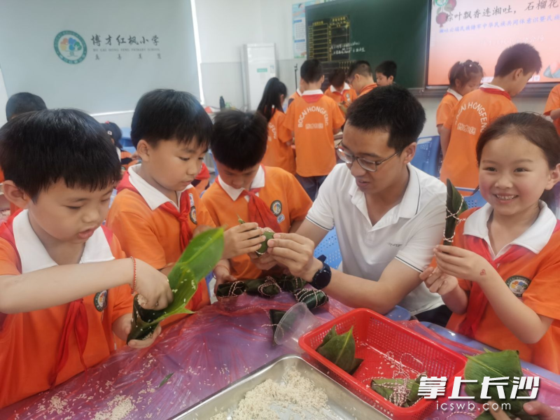 两地师生动手包粽子。