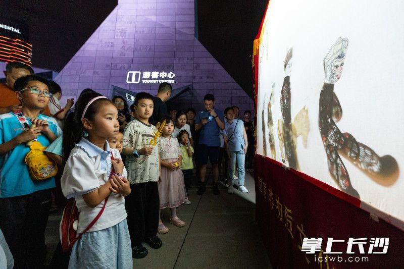 5月30日晚，在长沙滨江文化园中心广场举行的“烟火长沙·非遗好物市集”，小朋友被皮影戏吸引。 长沙晚报全媒体记者 董阳 摄