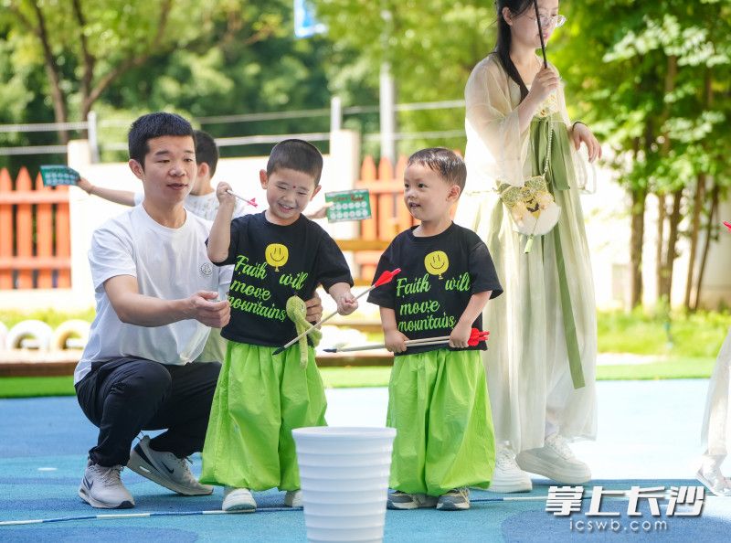 5月30日，雨花区教育局绿地城市幼儿园，端午六一双节游园会，两位小朋友开心地体验投壶游戏。  长沙晚报全媒体记者 邹麟 通讯员 蒋丽梅 摄