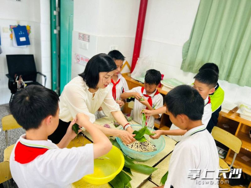 孩子们在家长校外辅导员的指导下动手包粽子。 均为长沙晚报通讯员黄婧供图