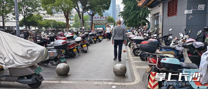 长沙东塘大都市商业街的多个出入口，密密麻麻挤满了电动车和共享单车，车辆层层叠叠。