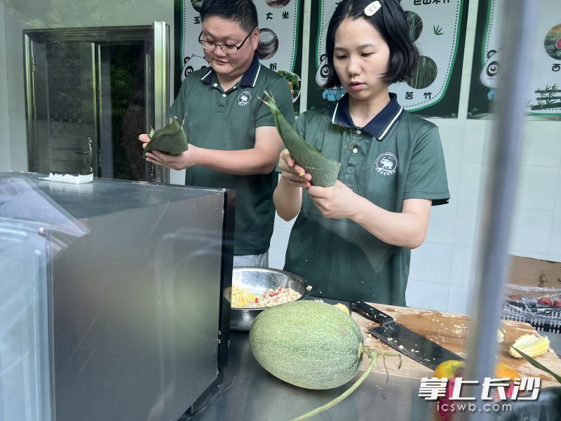 饲养员在为大熊猫包粽子。